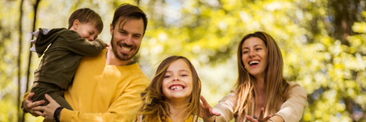 Familie - Mutter, Vater, kleine Tochter und kleiner Sohn - sind im Wald unterwegs.