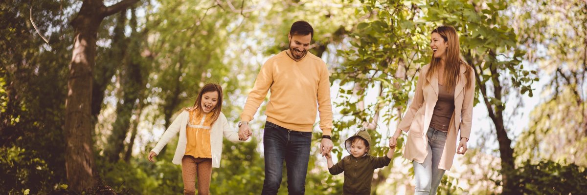 Familie - Mutter, Vater, kleine Tochter und kleiner Sohn - sind im Wald unterwegs.