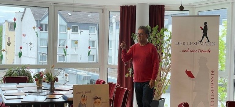 Der Workshopleiter steht neben seinem Rollup Der Workshopleiter steht neben seinem Rollup